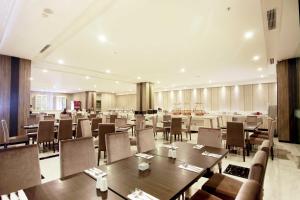 a large dining room with tables and chairs at Grand Karlita Hotel Purwokerto in Purwokerto