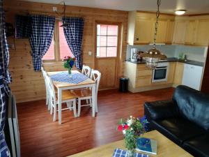 cocina y sala de estar con mesa y sillas en Adventure Camp Mehamn, en Mehamn