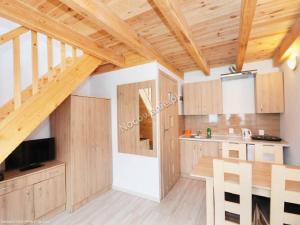 a kitchen with wooden cabinets and a wooden staircase at Pod Akacją in Rewal