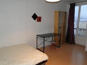 パリにあるアパルトマン トロカデロのベッドルーム1室(ベッド1台、テーブル、窓付)