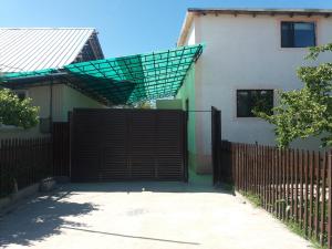 un cancello di fronte a una casa con una recinzione di Macedon Guest House a Barskoon