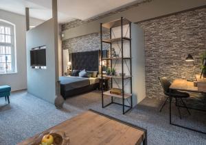een woonkamer met een bed en een bakstenen muur bij Boardinghouse Emden in Emden