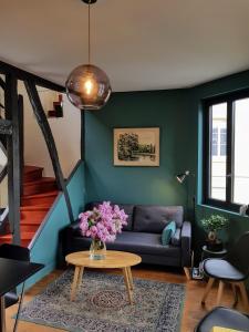 a living room with a couch and a table at Appartement typique Rouen centre tout confort in Rouen