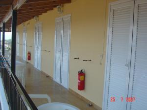 d'un couloir avec portes blanches et bouches d'incendie. dans l'établissement Fatiras Studios, à Kassiopi