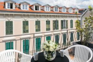 a table with a vase of flowers on a balcony at Hotel Florence Nice in Nice