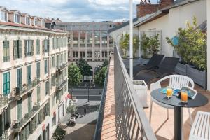 an apartment with a balcony with a table and chairs at Hotel Florence Nice in Nice