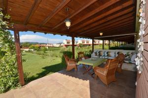 a patio with a couch and a table and chairs at Elios Villa Chalkidiki in Skala Fourkas