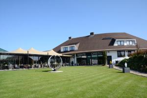 a large lawn in front of a building with a sculpture at Hotel Monte Cristo in Hoeselt