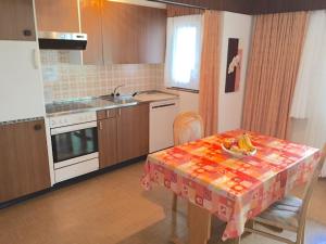 eine Küche mit einem Tisch und einer Schale Bananen drauf in der Unterkunft Ferienhaus Perle in Saas-Grund