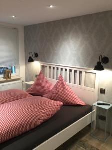 1 dormitorio con 1 cama con almohadas rojas y blancas en Landhaus Thome en Nideggen