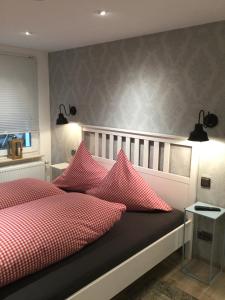 a bedroom with a bed with red and white pillows at Landhaus Thome in Nideggen