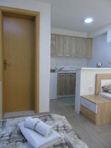 a kitchen with a door open to a room with a bed at Apartments Marysol in Kotor