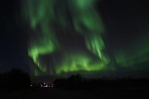 una imagen de la aurora boreal en el cielo en Old timber house, en Kalix