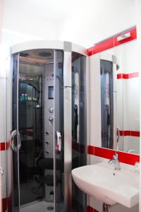 een badkamer met een glazen douche en een wastafel bij Hotel Villa Chiara in Terracina