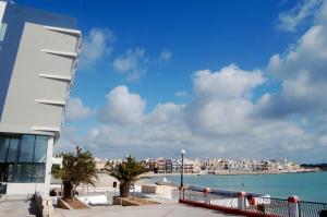 a building with a view of a body of water at Water's Edge Hotel in Birżebbuġa