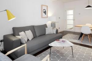ein Wohnzimmer mit einem grauen Sofa und einem Tisch in der Unterkunft Marina by FeelFree Rentals in San Sebastián