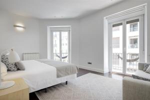 ein weißes Schlafzimmer mit einem Bett und einem Sofa in der Unterkunft Marina by FeelFree Rentals in San Sebastián
