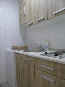 a kitchen with wooden cabinets and a sink at Apartments Marysol in Kotor +33 photos
