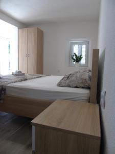 a bedroom with a large bed and a wooden table at Apartments Marysol in Kotor
