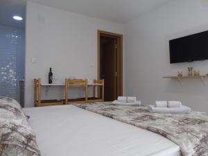 a bedroom with a large white bed with a flat screen tv at Apartments Marysol in Kotor
