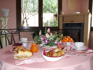 a table with a pink table cloth with food on it at Keira B&B in Quartucciu