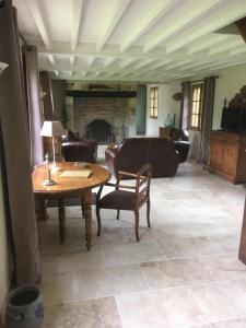 a living room with a table and chairs and a fireplace at L'auberge du Mont in Le Breuil-en-Auge
