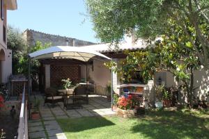 a patio with a table and an umbrella at Keira B&B in Quartucciu