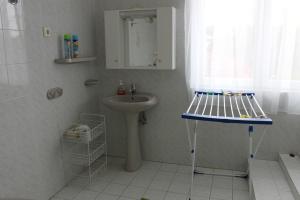 a white bathroom with a sink and a shower at Orwa Vendégház in Zalakaros +16 photos