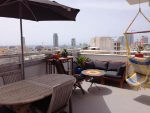 a balcony with a table and chairs and an umbrella at DUPLEX TERRACES TEL AVIV. in Tel Aviv