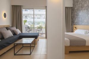 馬蓋洛夫的住宿－HM馬提尼克酒店，一间卧室配有一张床、一张沙发和一张桌子
