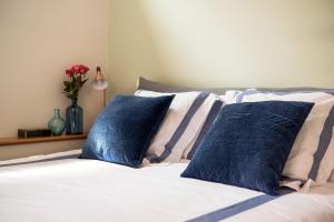 a bed with blue and white pillows and a vase of flowers at Lora Center apartment in Como