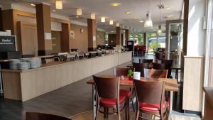 a restaurant with a bar with chairs and tables at Dream Inn Hotel Regensburg Ost in Regensburg