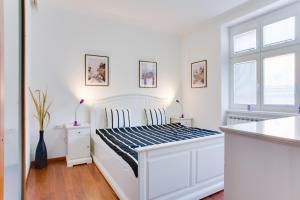 Un dormitorio blanco con una cama blanca y una ventana en Royal Apartment near river - Nek4th en Praga