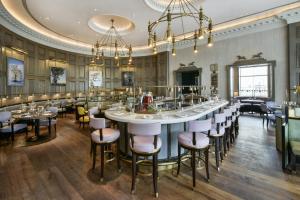 a large dining room with a large table and chairs at The Langham London in London