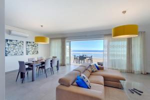 a living room with a couch and a dining room at Seafront Apartment Sliema in Sliema