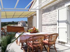 patio con mesa y sillas en el balcón en Apartments Dalmatino, en Rukavac