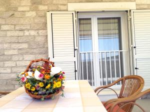 una cesta de flores sentada sobre una mesa en Apartments Dalmatino, en Rukavac