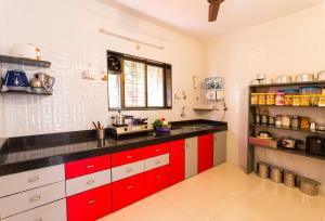 a kitchen with red and white cabinets and a sink at Shri Laxmi Narayan Bungalow in Mahabaleshwar