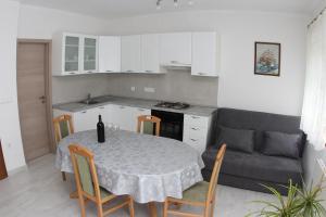 a kitchen and dining room with a table and a couch at Apartmani Ivanković in Vrisnik