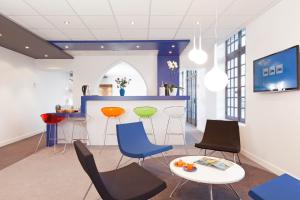 a waiting room with chairs and a table and a bar at ibis Styles Vannes Gare Centre in Vannes