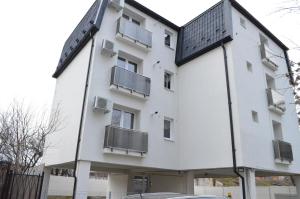 ein weißes Gebäude mit Fenstern und einem Dach in der Unterkunft Alexys Residence 5 in Iaşi