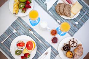 a table with plates of food and glasses of orange juice at Grupotel Maritimo in Port d'Alcudia
