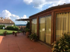 a large wooden house with a patio with plants at B&B Le Balze in Reggello