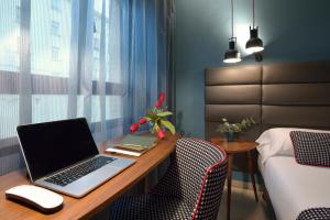 a room with a desk with a laptop computer on it at Hotel Pamplona Plaza in Pamplona