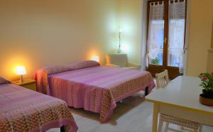 1 Schlafzimmer mit 2 Betten, einem Tisch und einem Fenster in der Unterkunft Sapore di Mare in Salerno