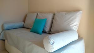 un sofá con dos almohadas azules encima en Merlo Centro Aparts en Merlo