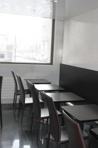 a dining room with tables and chairs and a window at Hotel The Originals du Grand Monarque Nantes Gare in Nantes