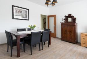 a dining room with a wooden table and black chairs at Altes Forsthaus in Manderscheid