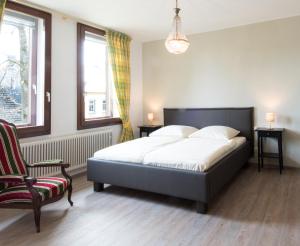 1 dormitorio con 1 cama y 1 silla en Altes Forsthaus, en Manderscheid