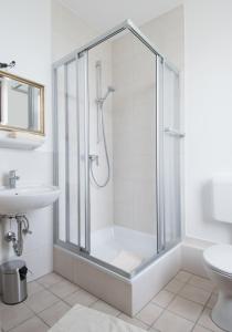 a white bathroom with a shower and a sink at Altes Forsthaus in Manderscheid